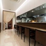 飲食店舗デザイン設計事例-新中国料理黄龍-大阪上本町-オープンキッチンのカウンター席とカーテンで仕切られたテーブル席の写真