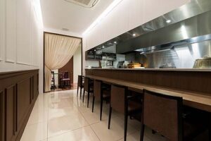 飲食店舗デザイン設計事例-新中国料理黄龍-大阪上本町-オープンキッチンのカウンター席とカーテンで仕切られたテーブル席の写真