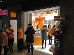物販店舗デザイン設計事例-スチームクリーム(STEAMCREAM)天神地下街店-ブランドカラーのオレンジの什器の見える店舗ファサード