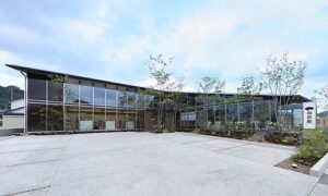 呉服店舗デザイン設計事例-和想館松江店-駐車場から見た庭越しの建物全景の昼の写真