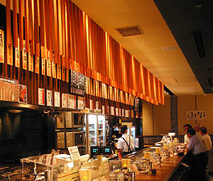 飲食店舗デザイン設計事例の赤垣屋、長い立ち呑みカウンターの上に吊られた木の縦格子