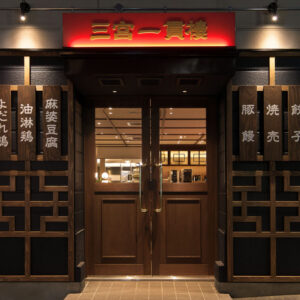 店舗デザイン設計実績事例、神戸の中華料理店三宮一貫樓元町北店店舗外観、暖かい雰囲気の店内が見える入口扉