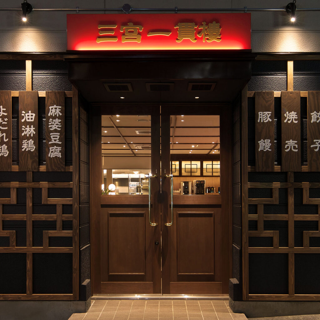 店舗デザイン設計実績事例、神戸の中華料理店三宮一貫樓元町北店店舗外観、暖かい雰囲気の店内が見える入口扉