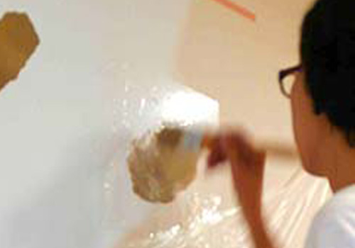 mamma cafe しんたに、壁に葉を描いているイラストレーター