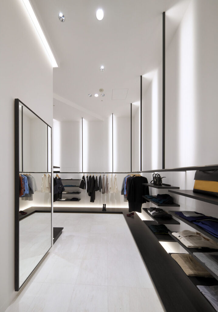 物販店舗デザイン設計実績事例、大阪梅田アパレルセレクトショップ、ピュアポニーディアモール大阪店、白い壁と黒い什器と温かい間接照明で構成される空間