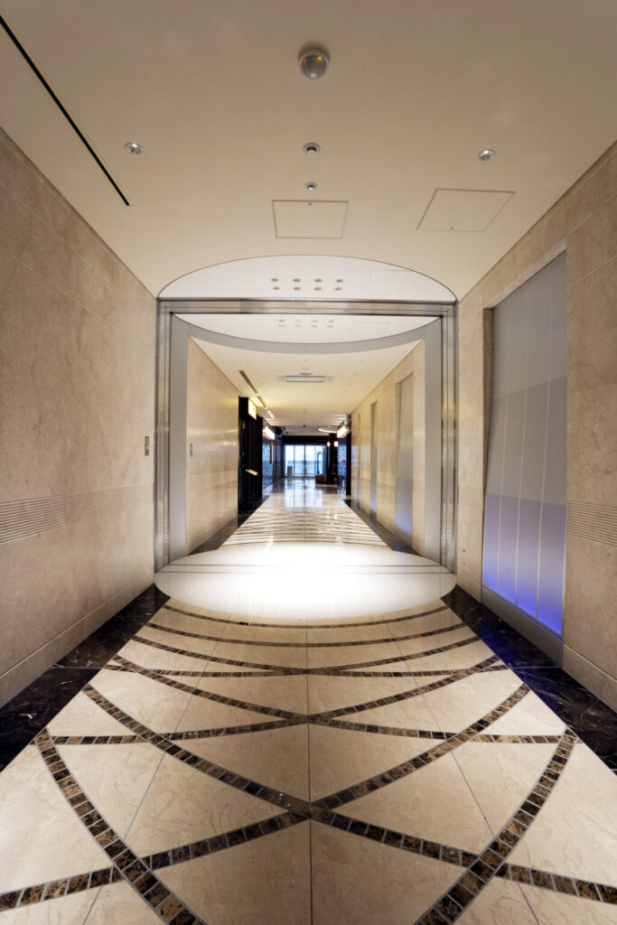 商業施設商環境デザイン実績事例、淀屋橋オドナ、B棟２階通路。２つの建物を繋ぐ壁が続く通路に、時間の流れを感じる色による演出を加えている。