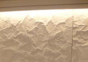 京都総合観光案内所の間接照明の掛かったシワシワ加工パネル