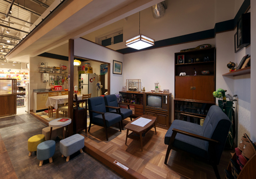 飲食店舗デザイン設計実績事例、エンターテインメントカフェtonarinotonari、カフェ客席の奥にある70年代の実家のようなダイニングキッチンとリビングルーム