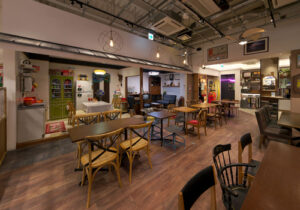 飲食店舗デザイン設計実績事例、エンターテインメントカフェtonarinotonari、カフェ客席の奥にある外壁が取られた様な70年代風実家コーナー