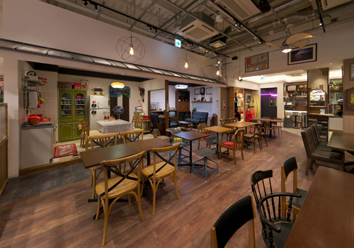 飲食店舗デザイン設計実績事例、エンターテインメントカフェtonarinotonari、カフェ客席の奥にある外壁が取られた様な70年代風実家コーナー