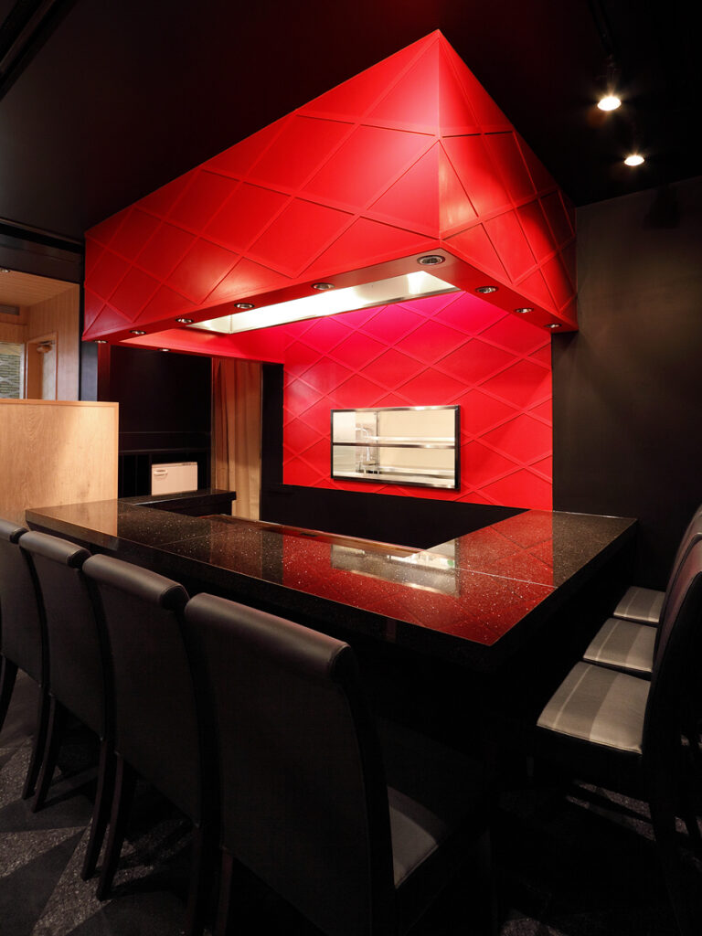 店舗デザイン設計実績事例、大阪市のお好み焼き店、南地千房心斎橋、立ちのぼる炎をイメージした赤の黒の鉄板カウンター